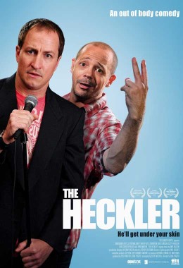 Film poster for The Heckler showing one man with a microphone and another leaning out from behind him with two fingers in the air.